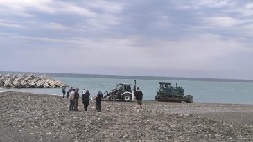 SAHİLDE GÜNEŞLENİRKEN İŞ MAKİNESİNİN ALTINDA CAN VERDİ