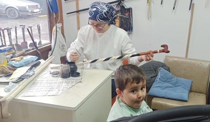 BİR ELİYLE TORUN SALLIYOR, DİĞER ELİYLE DÜNYACA ÜNLÜ BASTONLARI ÜRETİYOR